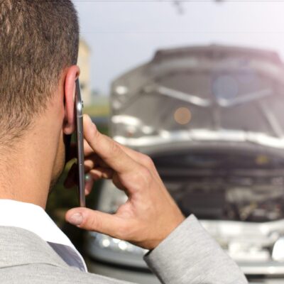 hombre pie junto al vehiculo roto llamando al servicio remolque